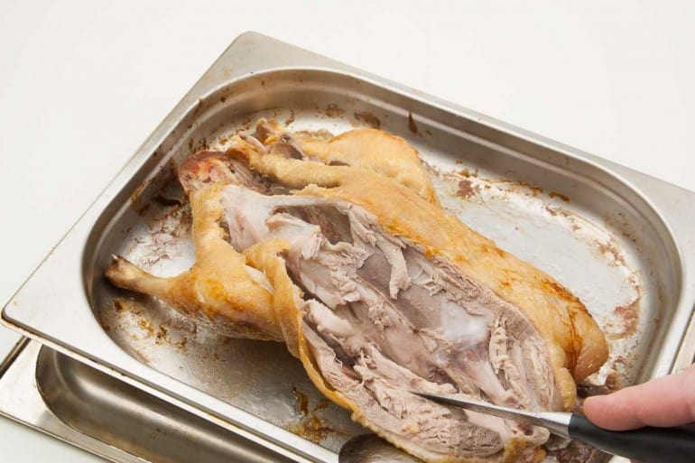 Fold the chest away and cut down from the duck carcass.