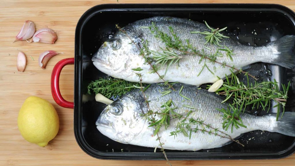 Prepare dorade for grilling with herbs and garlic