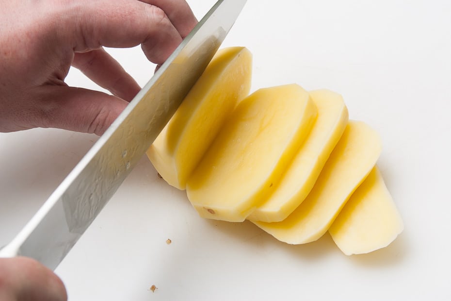 first step after peeling: slicing potatoes for french fries
