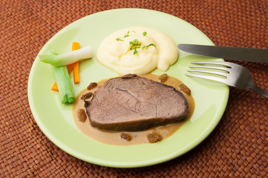 sauerbraten with mashed potatoes, vegetables and sauce. a classic german dish!