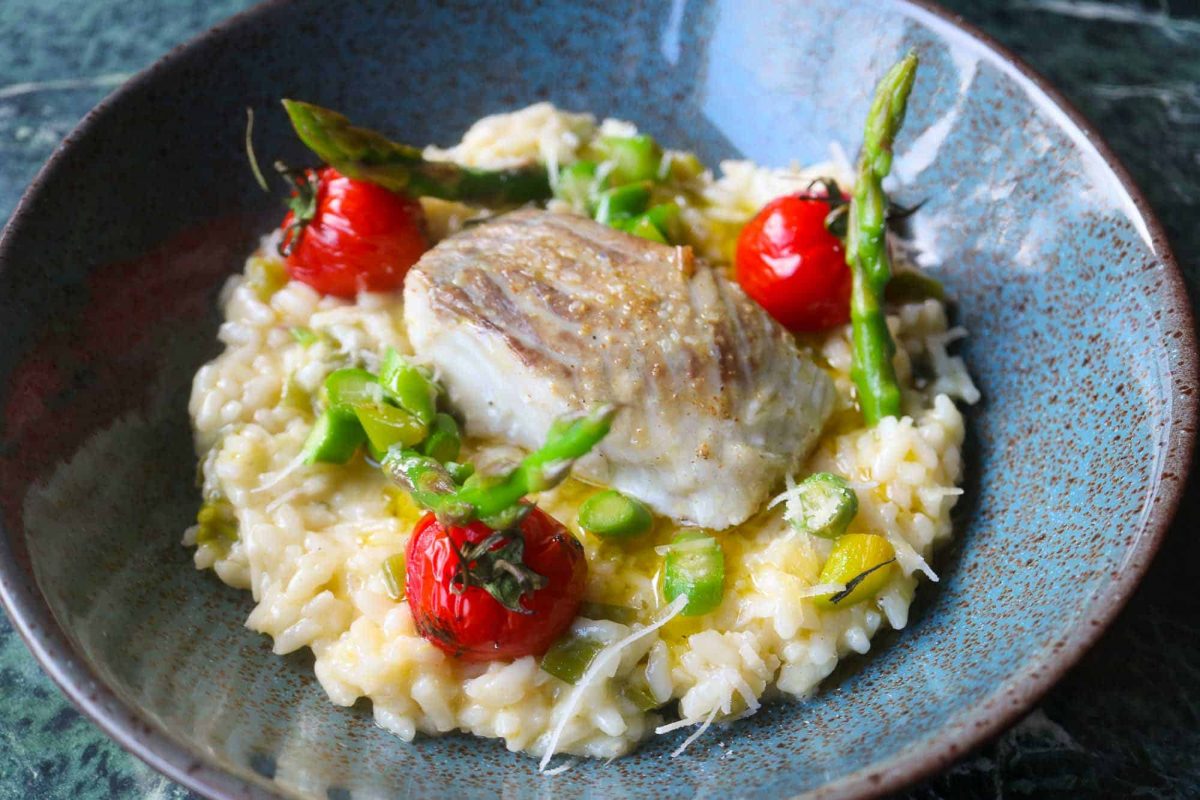 Lemon risotto served with asparagus, tomatoes and saithe.