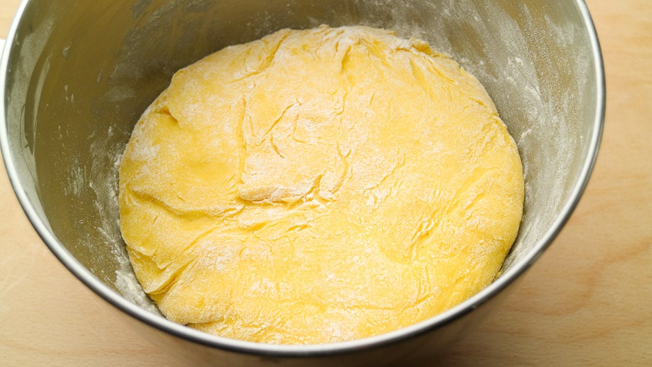 Risen yeast dough in a warm mixing bowl.