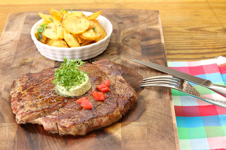 Rib eye steak served with fried potatoes.