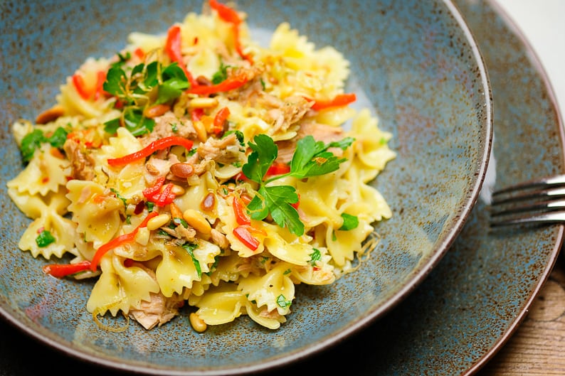 Pasta with tuna, garlic and parsley served in a deep plate.