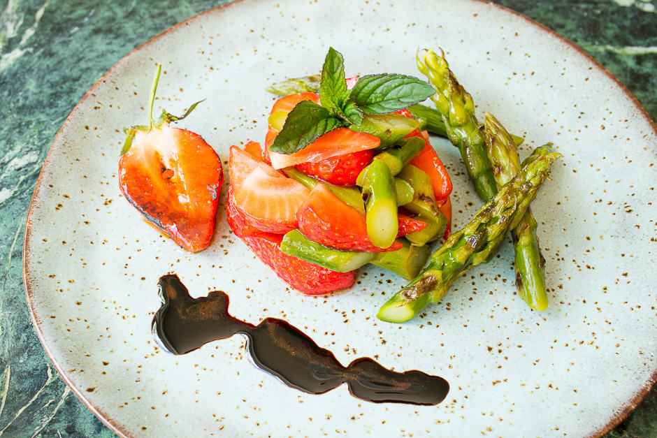 Asparagus salad with strawberries served with balsamic glace, which is boiled down and greatly reduced balsamic.