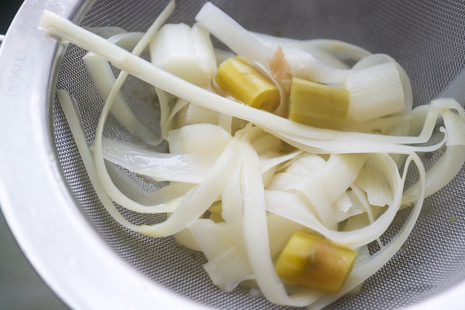 Strain the asparagus soup through a sieve.