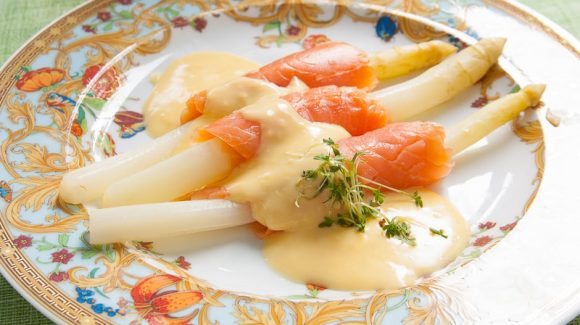 white asparagus with smoked salmon served with hollandaise sauce.