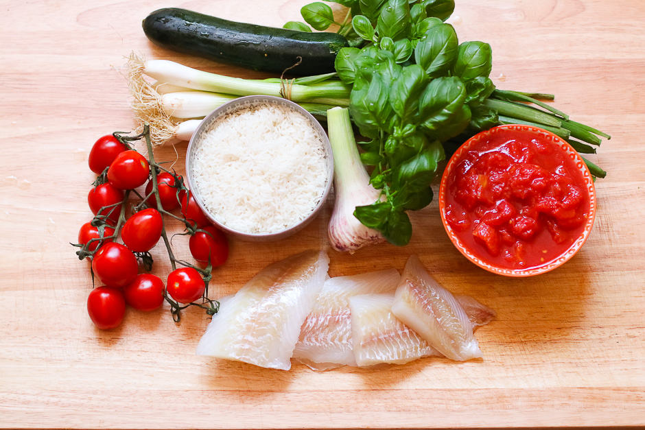 Ingredients for fish with a side dish of rice on the kitchen board.