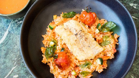 Cod fried in a pan served on Mediterranean rice.