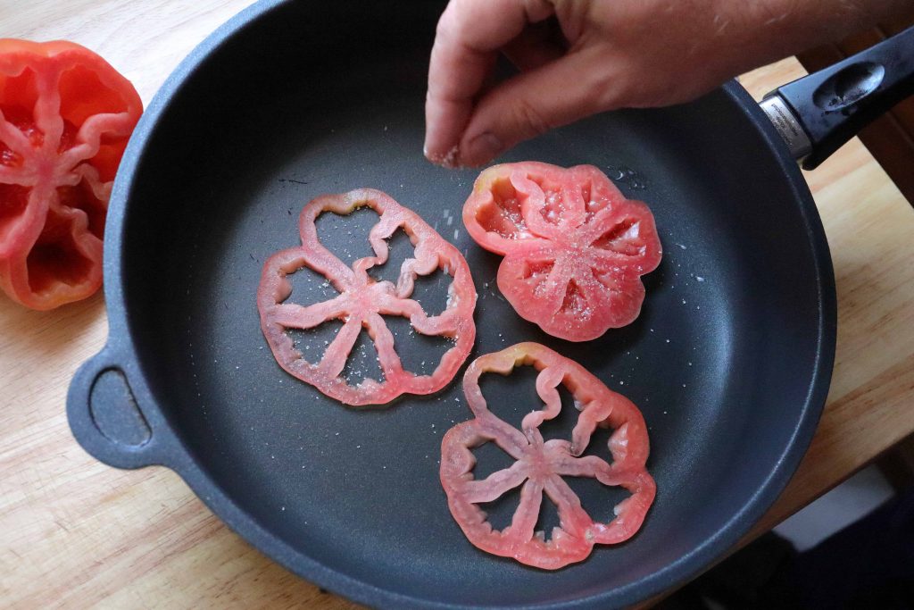 Season the tomatoes in the pan