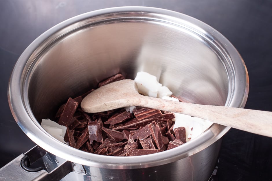 Sliced chocolate with coconut oil in a pot