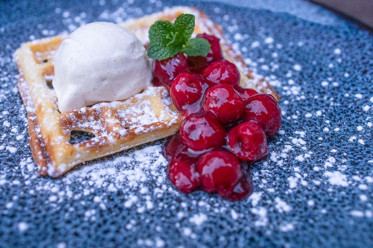 Waffles with ice cream and hot cherries