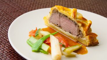 Beef Wellington recipe picture, served with vegetables and sauce
