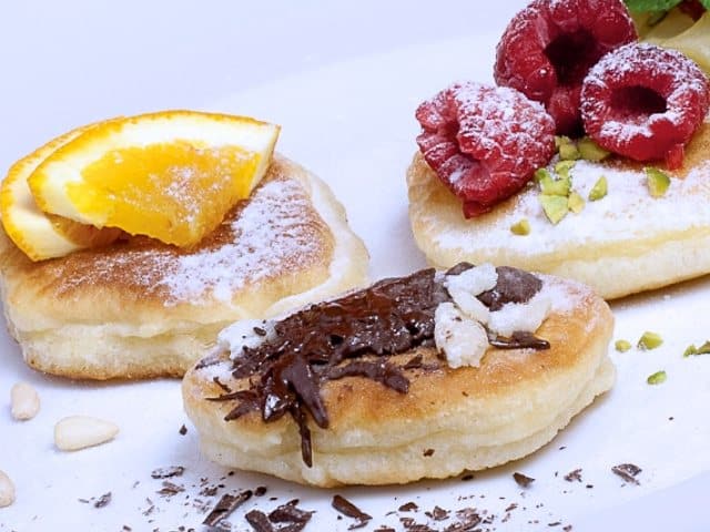 pancakes in different variations. with raspberries, with oranges, with chocolate and marzipan