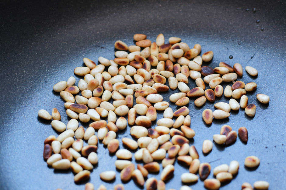 Roasted pine nuts in a pan.