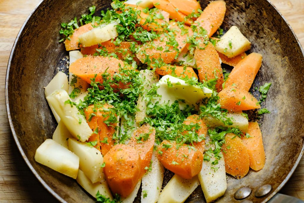 Root vegetables in the pan with butter and parsley