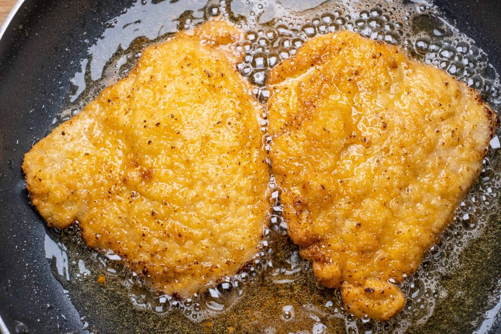 Turning breaded cutlets during frying
