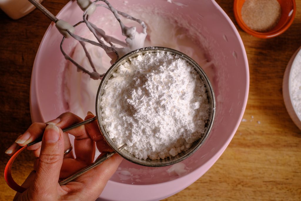 Sieve the icing sugar into the egg whites