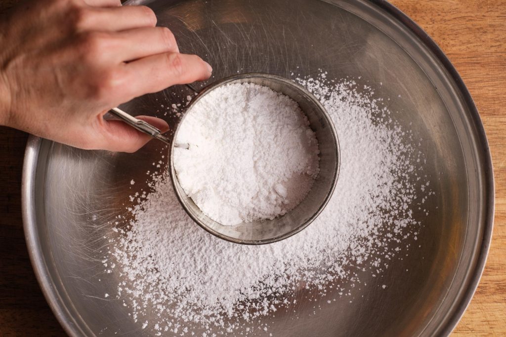 Sift powdered sugar for vanilla crescents
