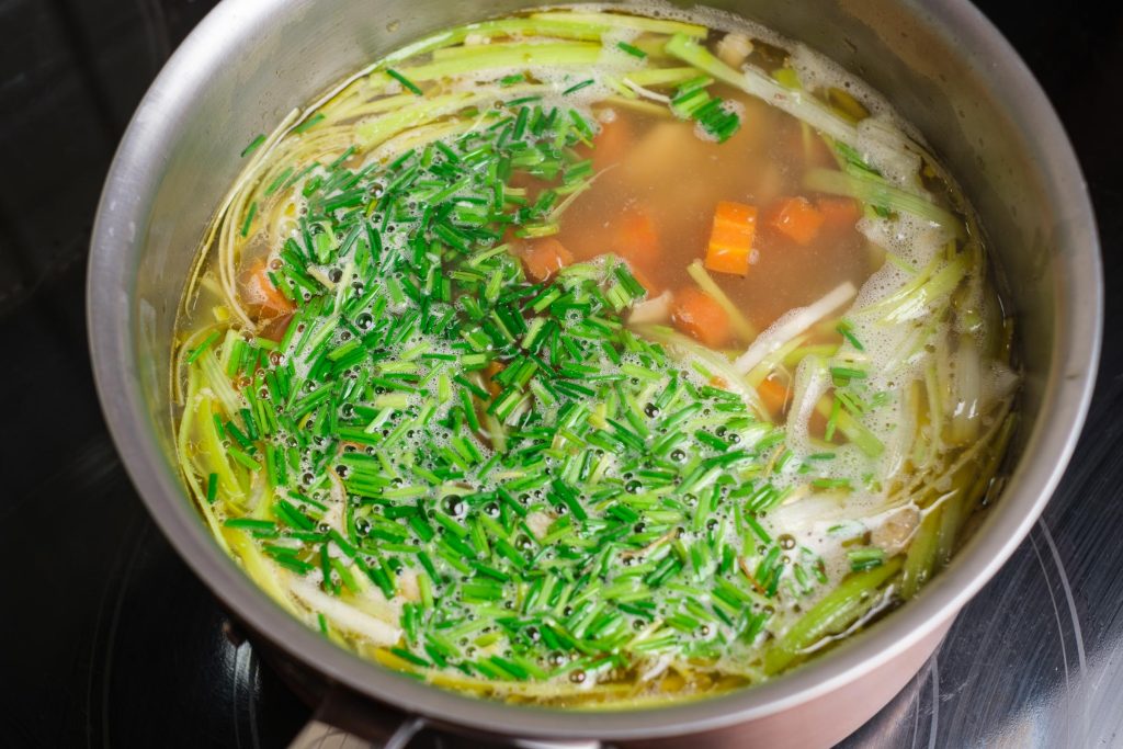 Chicken soup with chives in a pot