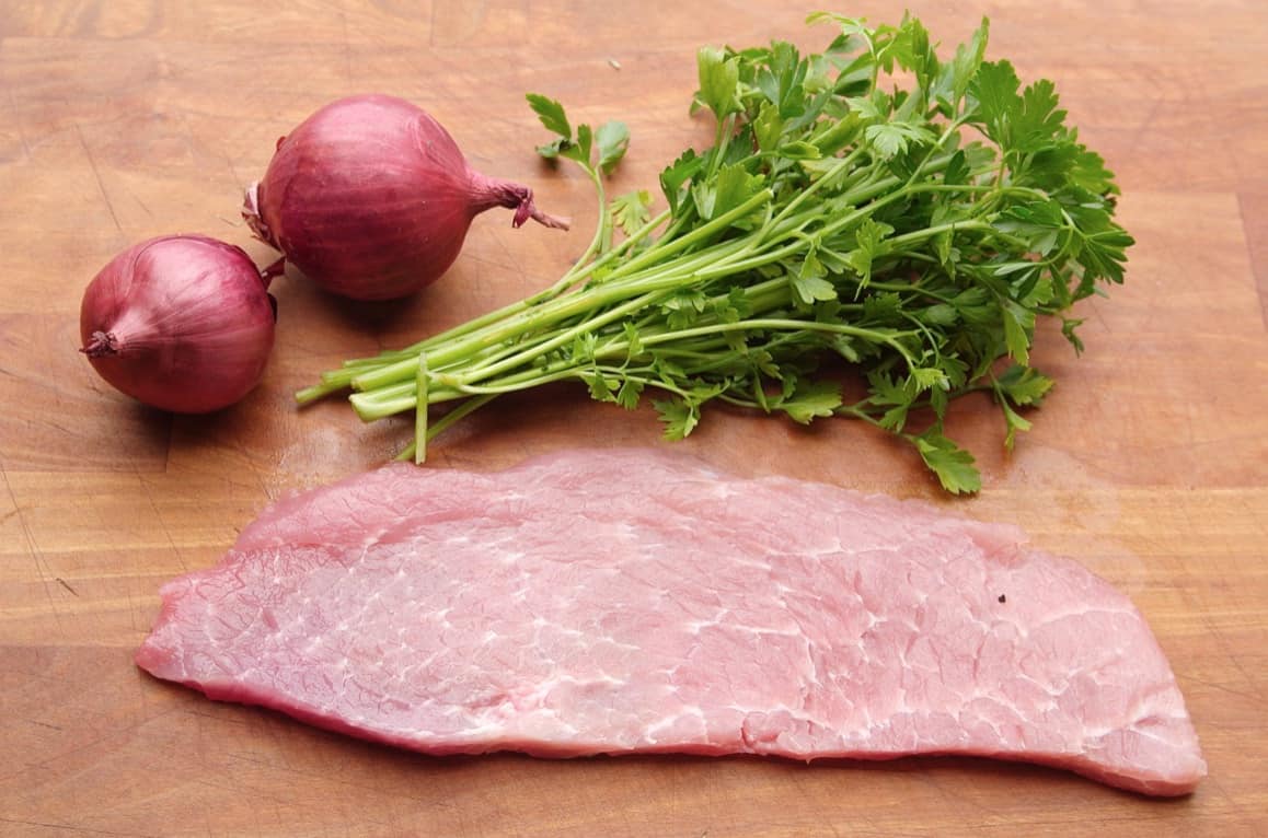 Fleisch für Wiener Schnitzel, bitte sorgfältig auswählen. Bild mit Schnitzel auf Brett mit schönem Umfeld.