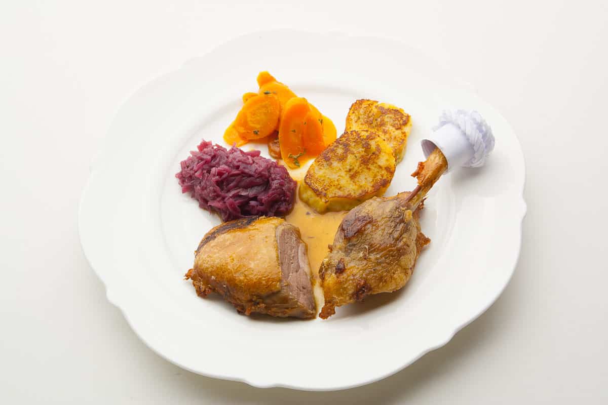 bayrische Ente, Entenbrust und Entenkeule knusprig zubereitet, hier eine Bauernente mit Blaukraut, glasierten Karotten und Brezenknödel als Beilage.
