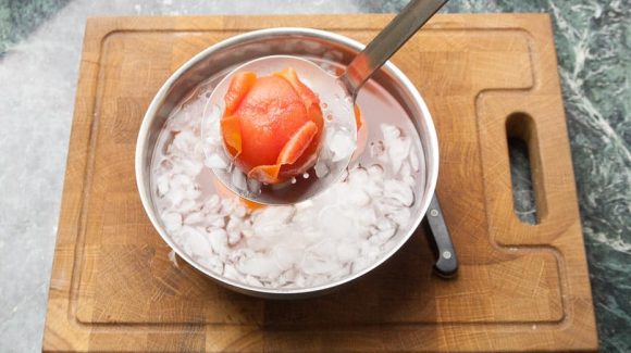blanchierte Tomaten aus dem kochendem Wasser in das Eiswasser legen.