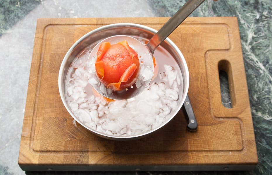 blanchierte Tomaten aus dem kochendem Wasser in das Eiswasser legen.