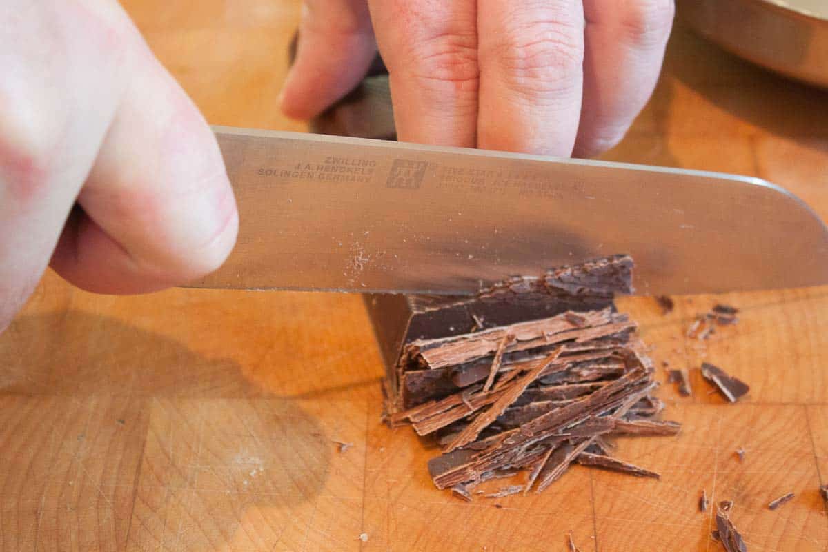 Dunkle Schokolade wird für die Wildsauce geschnitten.