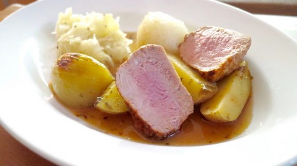 Schweinebraten schnell mit Beilagen Kartoffelknödel und Sauerkraut und Gemüse und Sauce angerichtet.