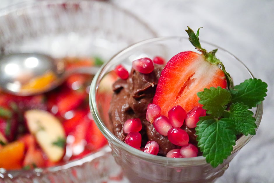 Veganes Schokoladenmousse dekoriert mit Minze, Erdbeere, Granatapfelkerne