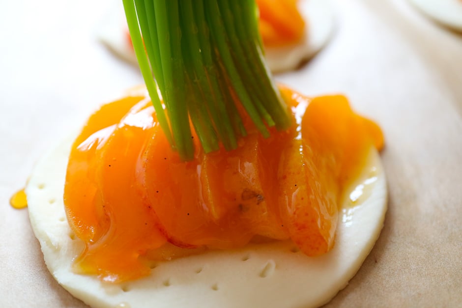 Aprikosen auf Blätterteig mit Rum-Marmelade bestreichen