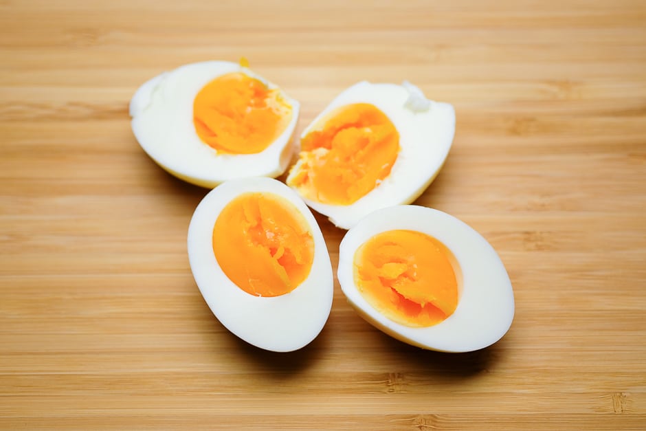 Gekochte, geschälte und halbierte Eier auf einem Küchenbrett