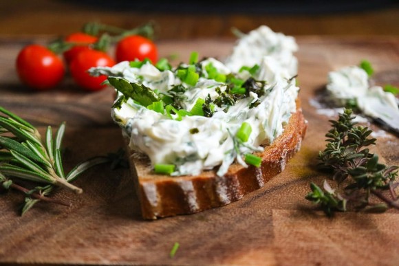 Kräuterquark auf dem Brot mit Umfeld nah fotografiert.