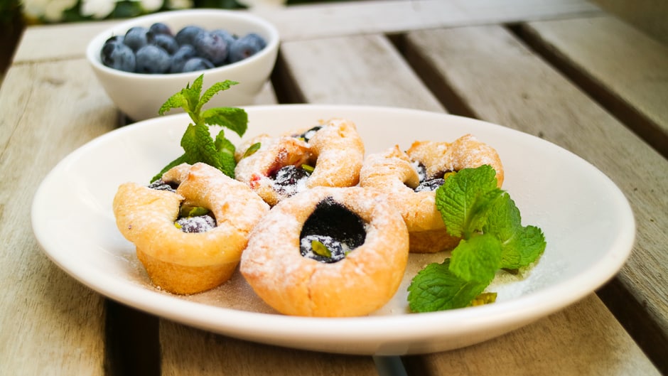 Heidelbeeren die auch Blaubeeren heißen sind eine leckere Basis für Muffins. Muffins auf einem Teller angerichtet.