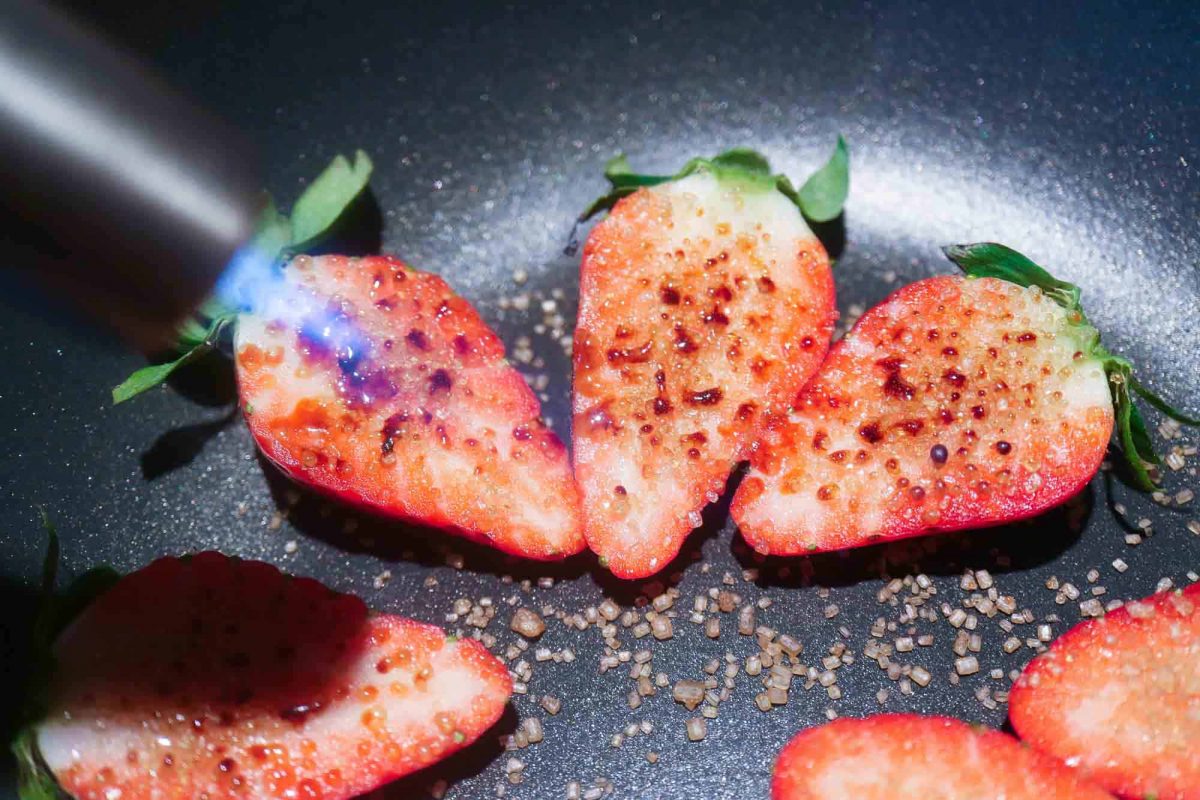 Erdbeeren mit Zucker karamellisieren.