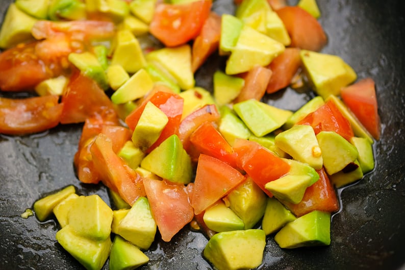 Tomaten und Avocado, gewürfelt beim marinieren mit Zitronensaft und Olivenöl für Couscous.