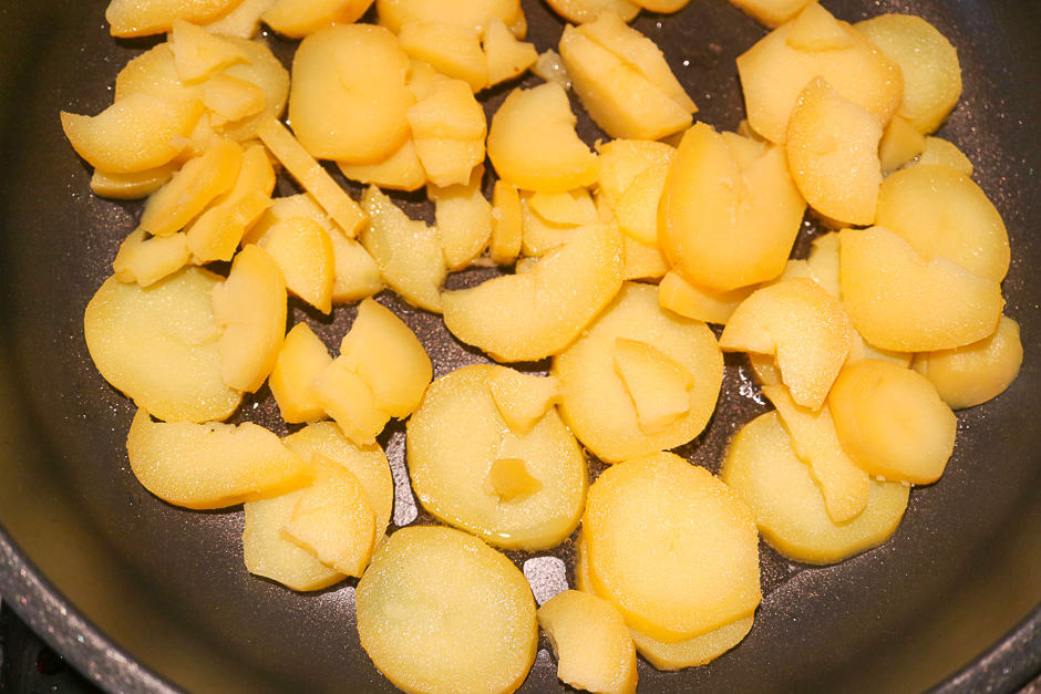 Kartoffelscheiben in der beschichteten Pfanne.