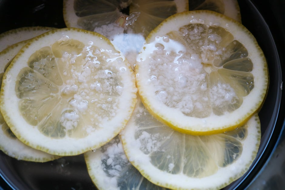 Zitronenscheiben beim Kochen in Zuckerwasser