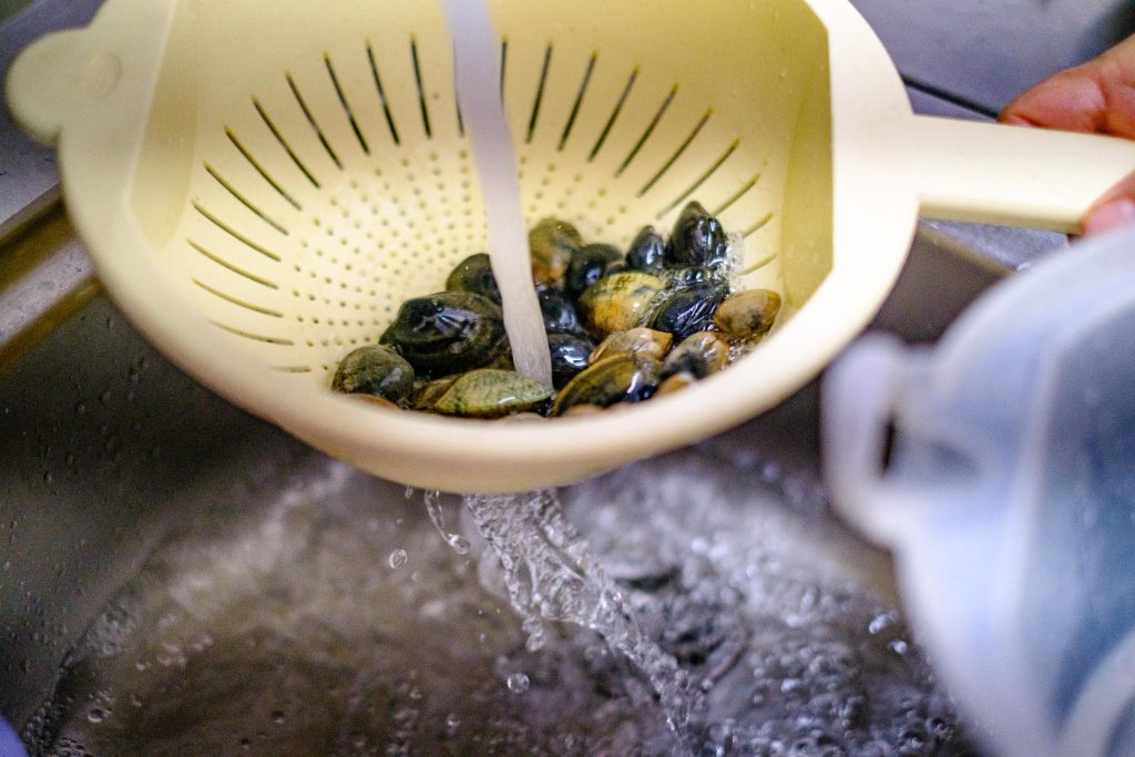 Muscheln im Sieb waschen