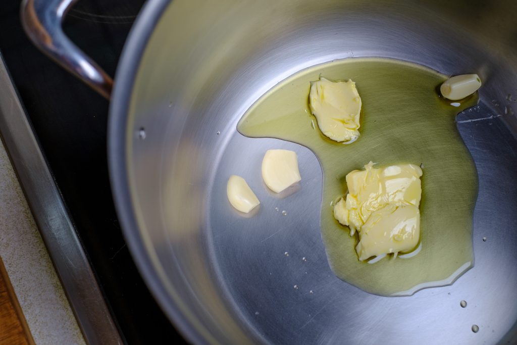Knoblauch mit Butter und Öl im Topf
