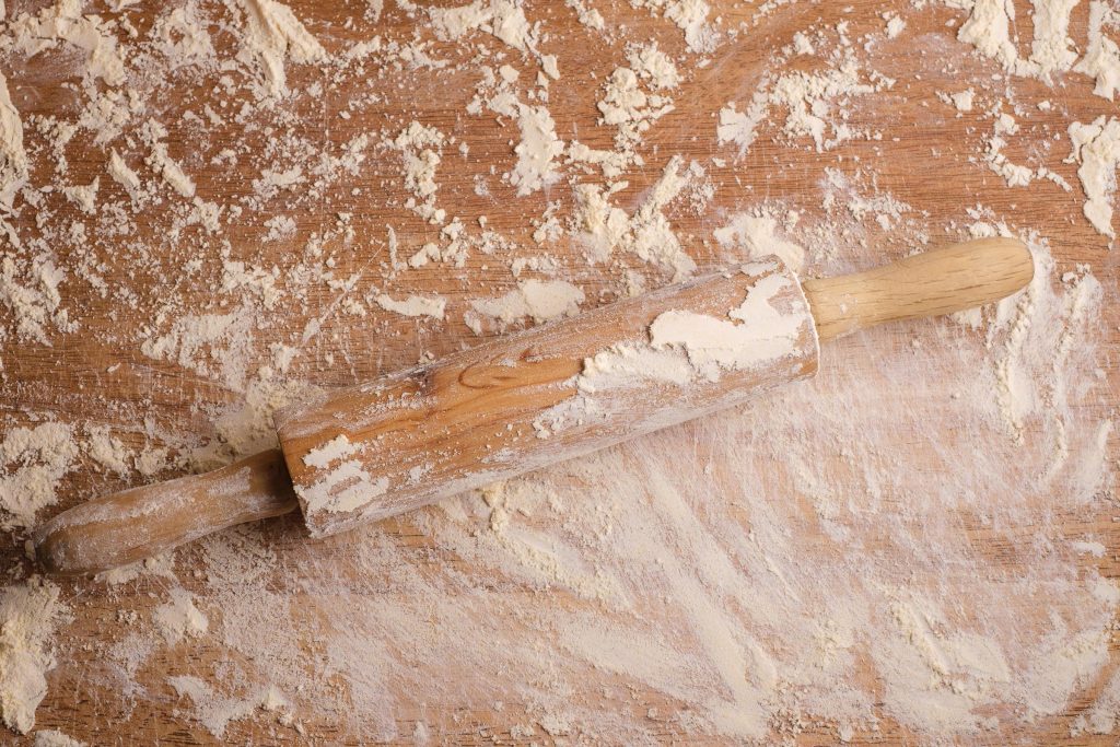 Nudelholz und Arbeitsfläche mit Mehl