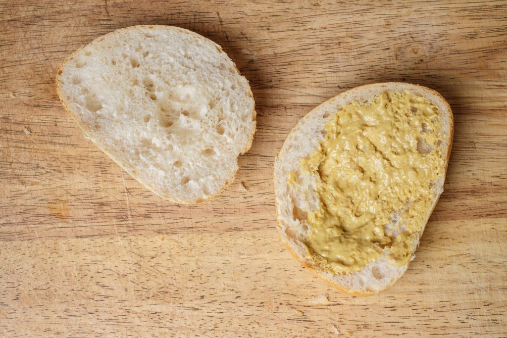 Semmel mit Senf bestrichen