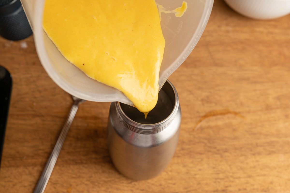 Eigelb und Butter in Sahnespender geben