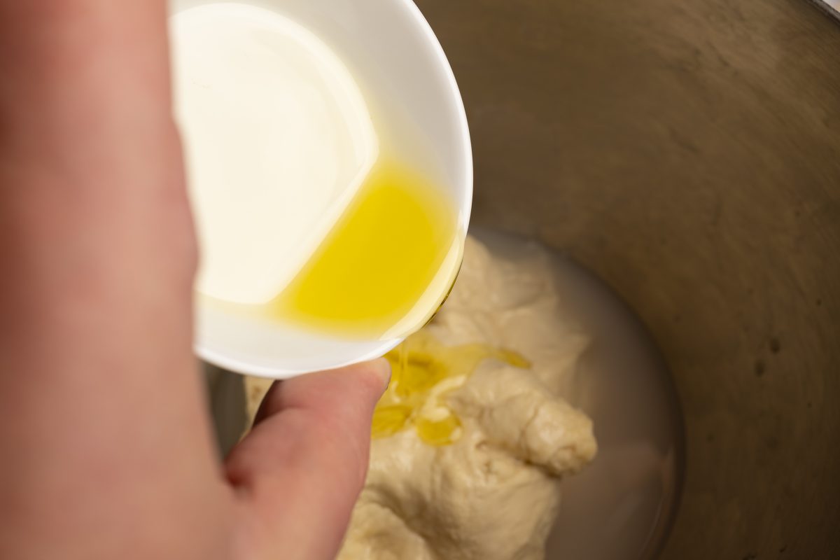 Olivenöl zum Mehl Wasser Teig geben
