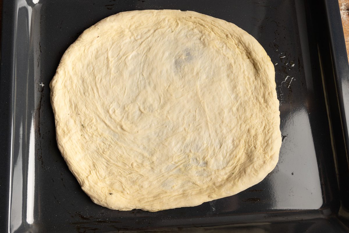 Pizzateig ausgeformt auf dem Backblech