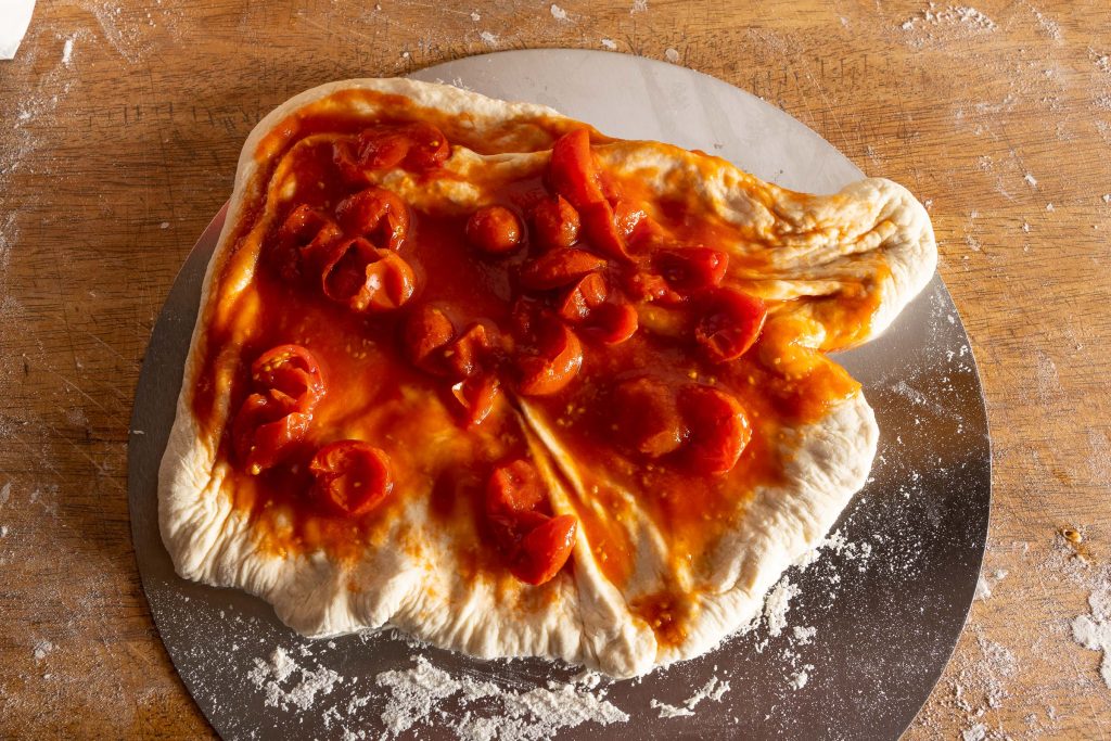 Pizzateig für Pizza Margherita mit Tomatensoße belegt