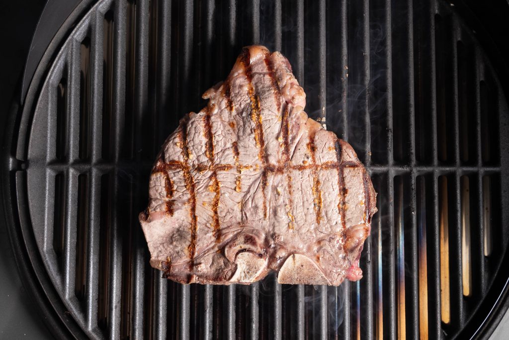 Porterhouse Steak gegrillt und gewendet auf dem Grillrost