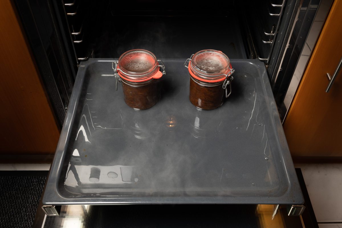 In Gläser gefülltes Pflaumenmus mit Deckel in den Ofen stellen