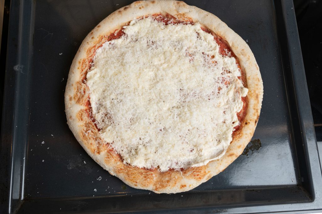 Pizzaboden mit Käse belegt